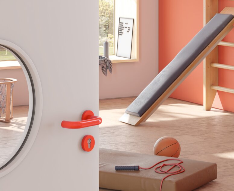 Door to a sports room of a kindergarten equipped with a lever handle in the colour orange made of polyamide