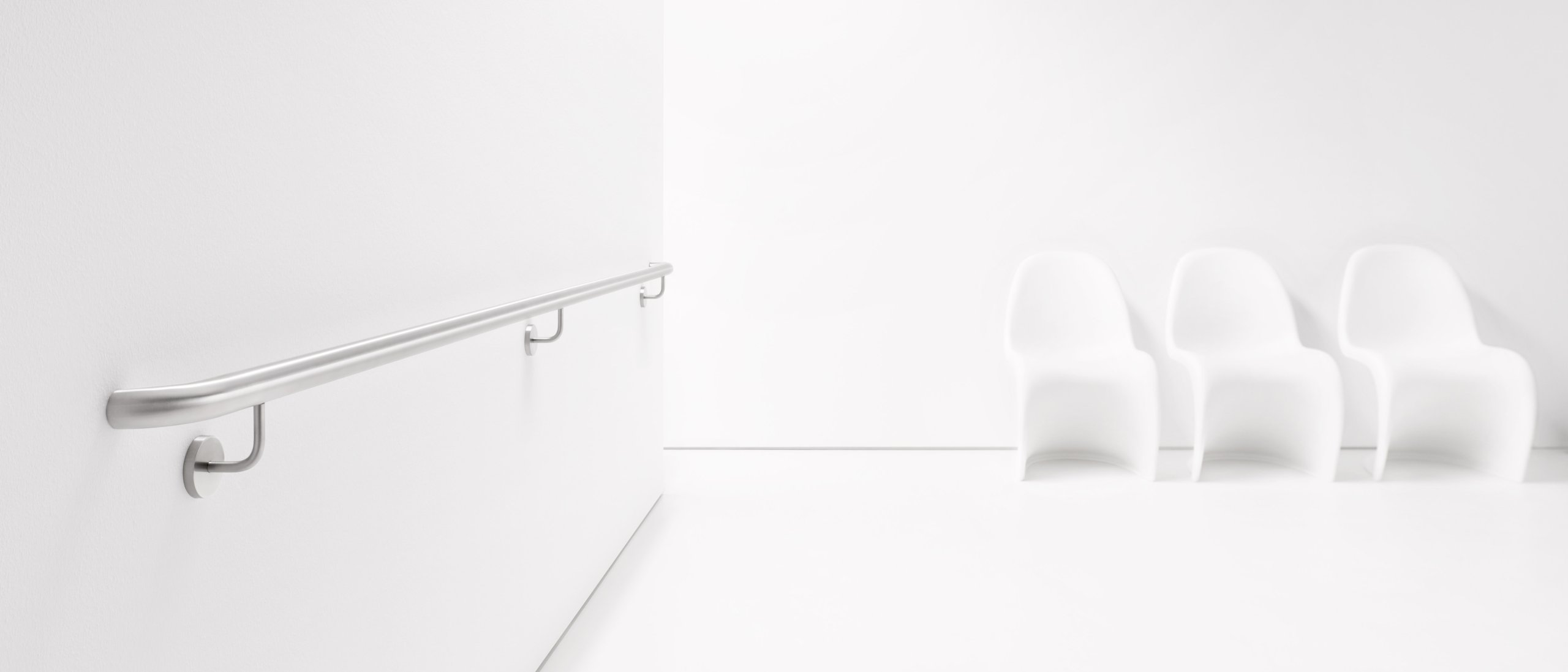 Stainless steel handrail attached to a white wall with three supports