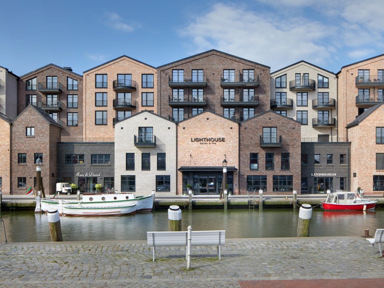Harbour basin with boats; on the opposite side of the shore are modern brick houses