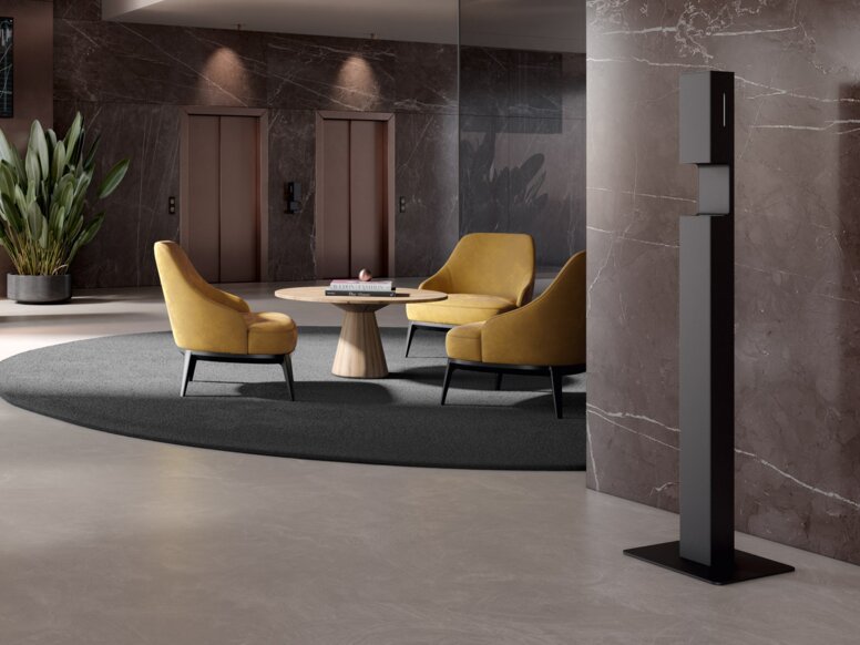 Modern reception area with a disinfectant dispenser column in matt black stainless steel